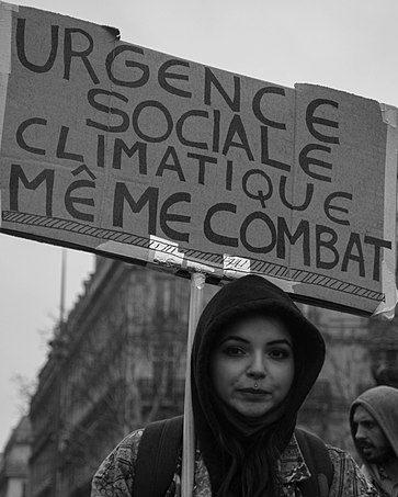 Photo de manif : urgence sociale et climatique, même combat. 
Manifestante jeune